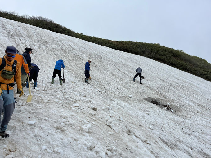 斜面に雪道を作るため掘っています。
