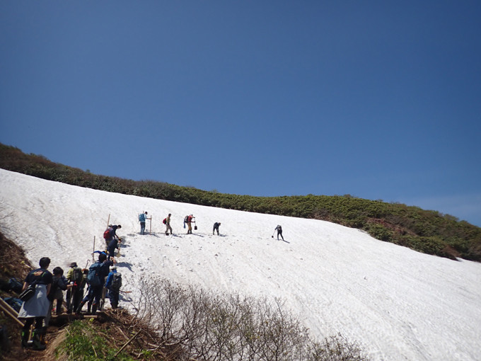 斜面に雪道を作るため掘っています。