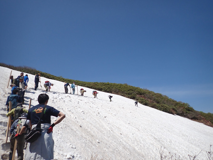 斜面に雪道を作るため掘っています。