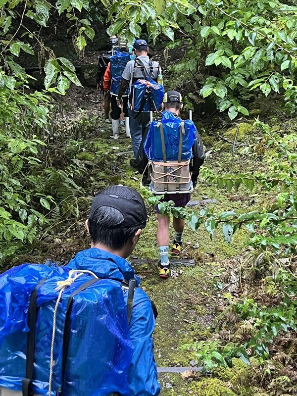 車両通行ができない山頂付近へ、飲料等を歩荷するボランティアスタッフ