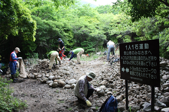 登山者のために小川から運んだ石を積む様子(九重の自然を守る会提供)