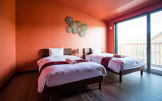 ブラッディオレンジを絞ったようなトロピカルなカラーが印象的なベッドルーム。
