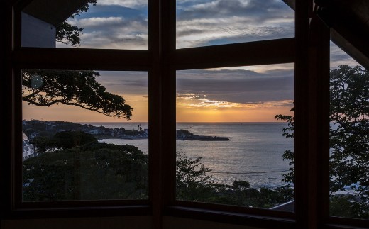 大海原の夕景を大きな三角窓から眺めながら