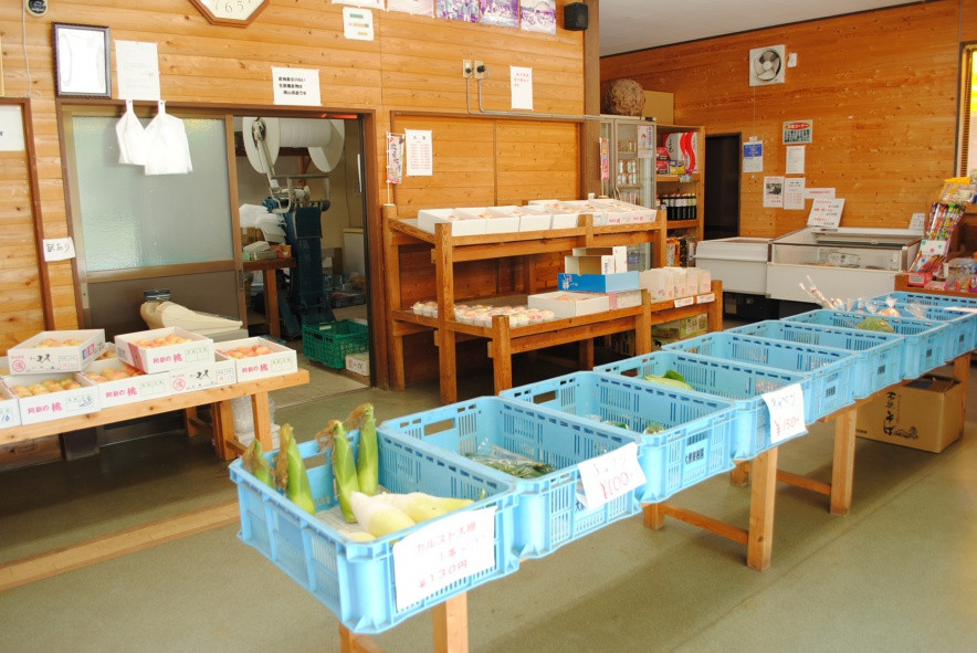 直売所店内、草間地域で採れた季節の野菜や果物が並びます。