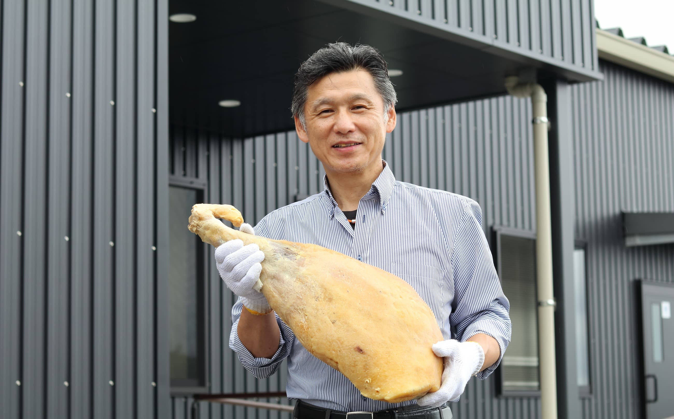 生ハム原木と田嶋社長※生ハムはカットした状態でお届けします。