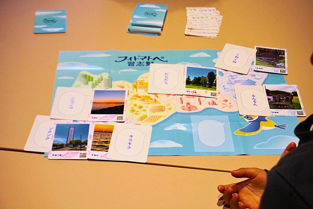 「ごつごつ」「るんるん」などの言葉(オノマトペ)カードと写真を合わせて遊ぶ新感覚のご当地ボードゲームです。