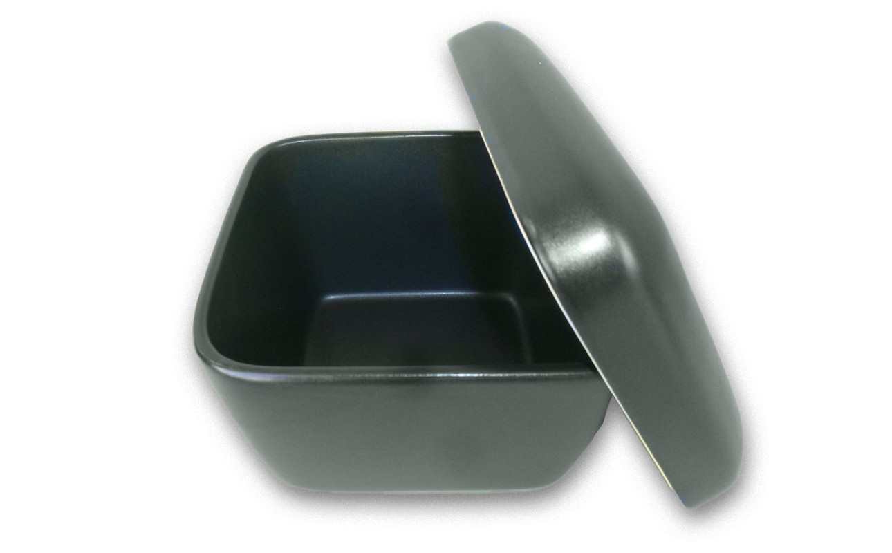 蓋が斜めに外れて半開きになっており、内部も黒く空になっている。艶のあるマットな質感で、弁当箱や保存容器のような形状。