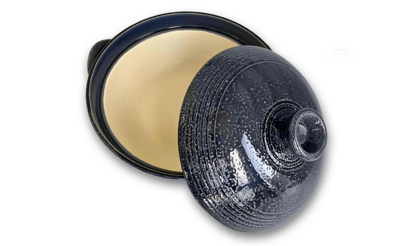 蓋が斜めに外れて半開きになっており、内部はベージュ色で空になっている。艶のあるマットな質感。