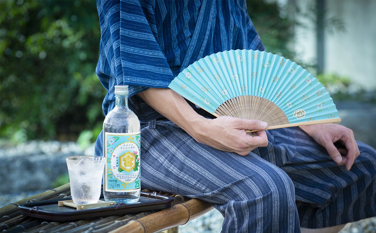 三重県四日市市のキンミヤ焼酎と扇子を持つ人