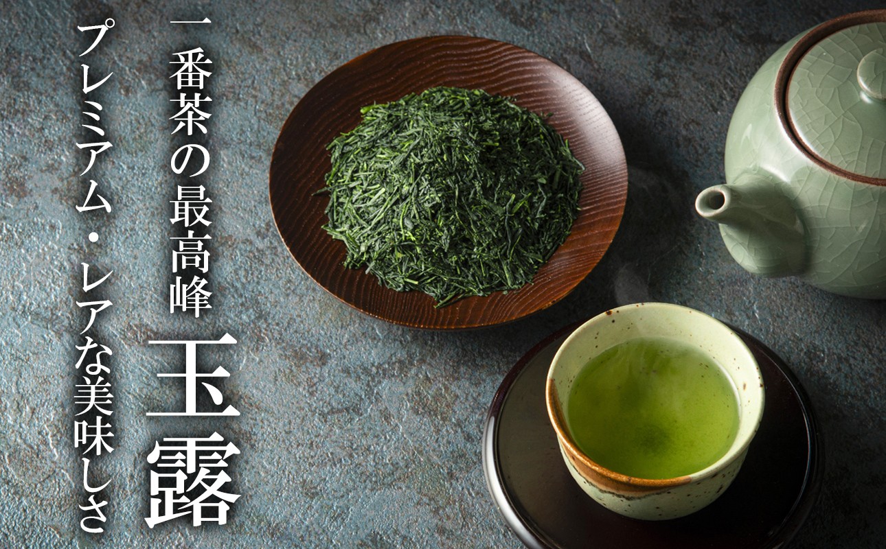 緑色の玉露茶葉が木の皿に盛られ、手前に緑茶の湯のみと急須。一番茶の最高峰　玉露